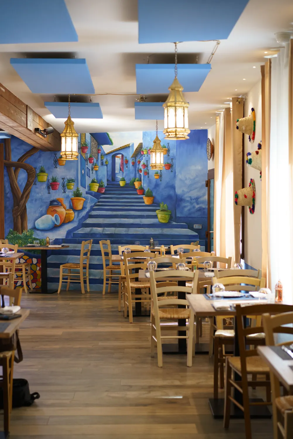 Sala interna con murale blu in stile marocchino e lampade sospese